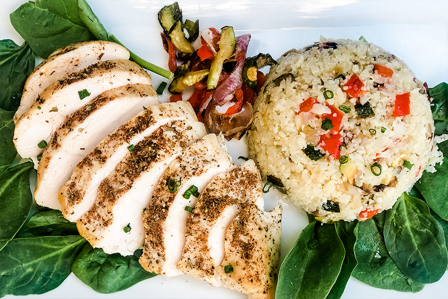 Slices ofJerk Spiced Chicken Breasts with Rice and Veggies