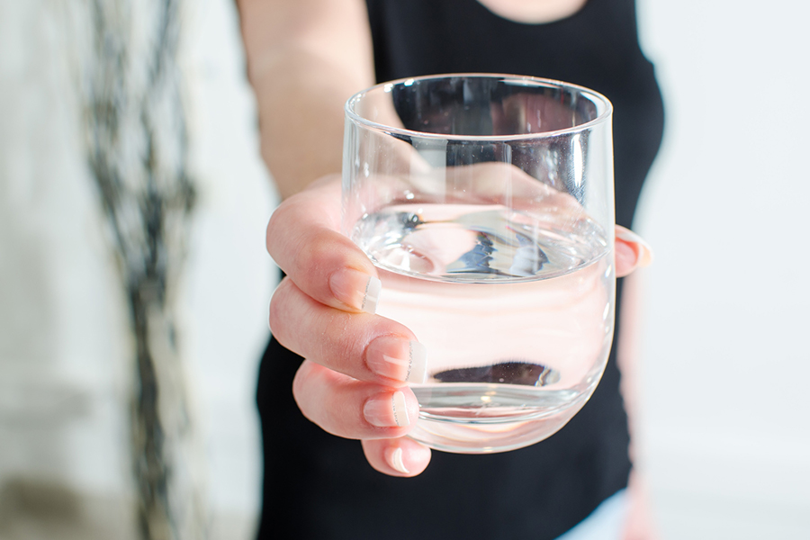 Woman holding out a glass of water