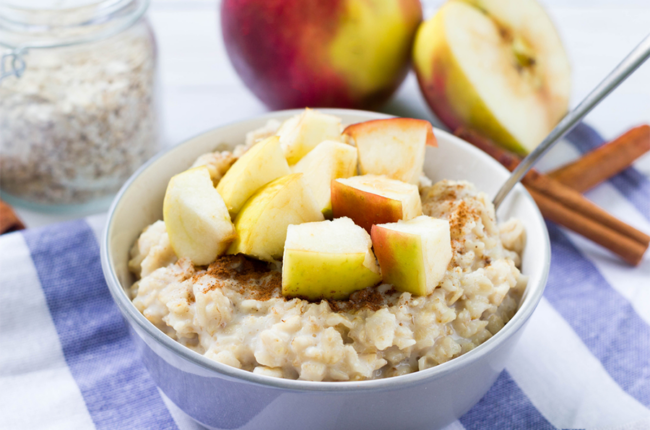 Bowl of oatmeal with chunks of apples on top