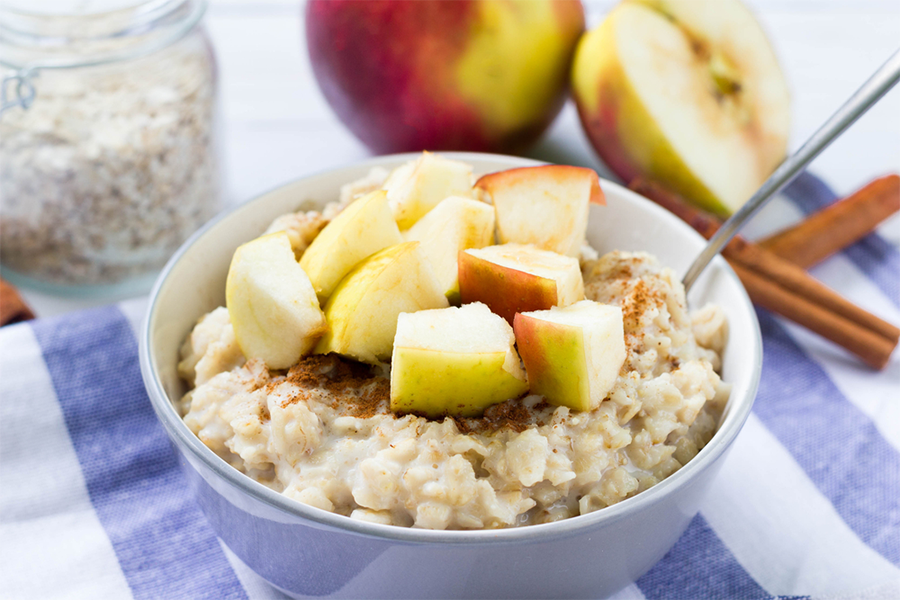 Bowl of oatmeal with chunks of apples on top