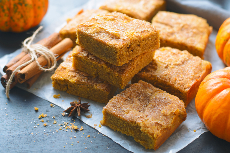 Stack of Pumpkin Spice Protein Squares with pumpkins and cinnamon sticks