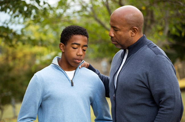 African American father and son deep in conversation