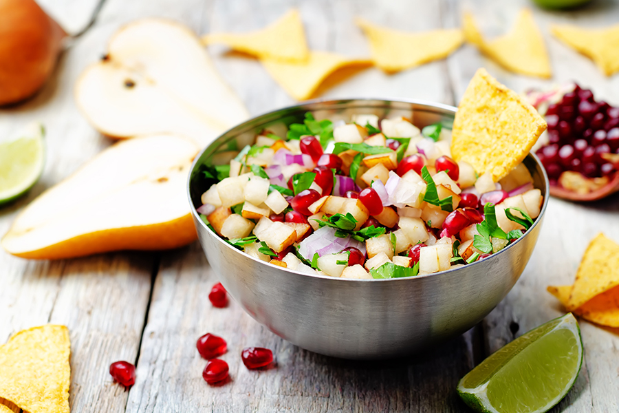 Metal bowl of Pomegranate Salsa with chips