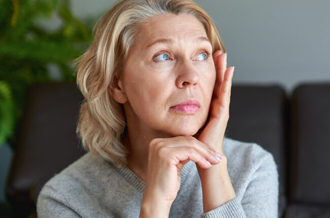 Woman sitting on couch looking stressed