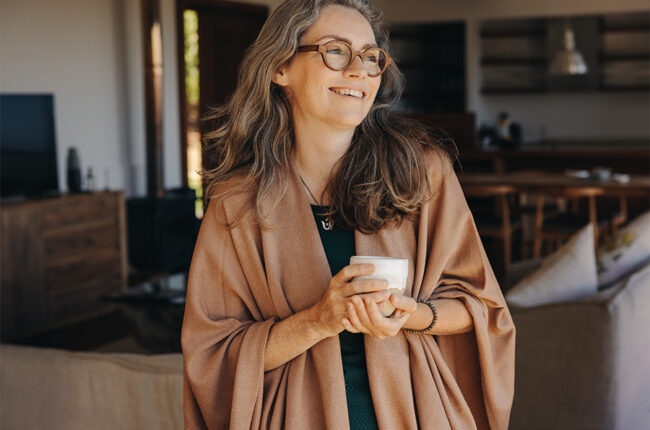 Happy senior woman smiling while holding a cup of tea