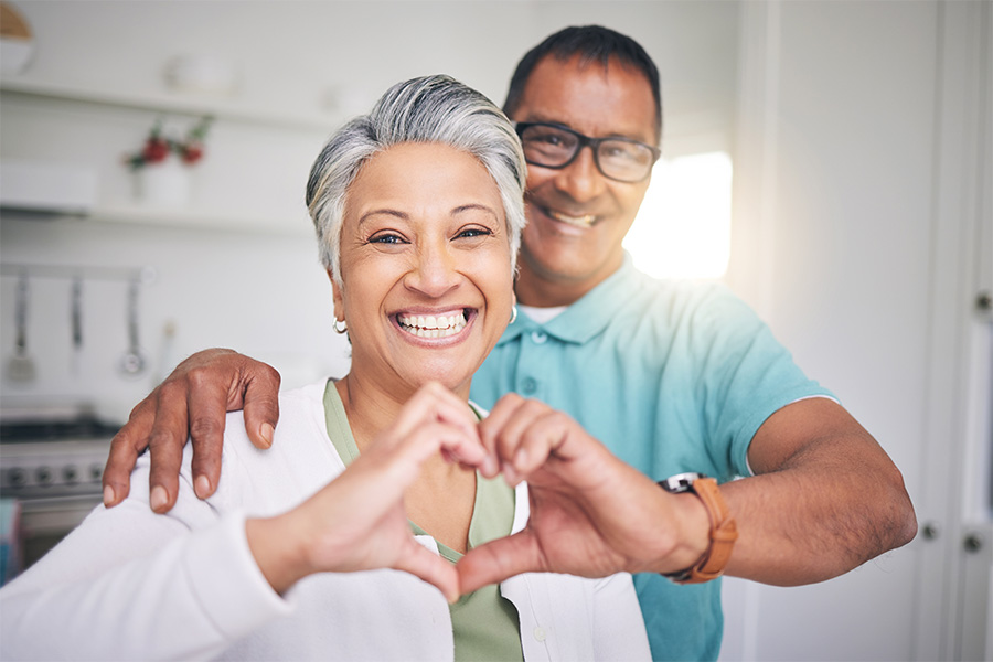 Heart hands, love and smile with portrait of old couple for support, happy and health. Happiness, kindness and peace with senior man and woman and gesture at home for embrace, trust and retirement