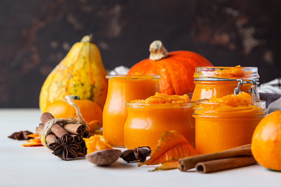 Pumpkins, squash, jars of pumpkin puree and fall spices