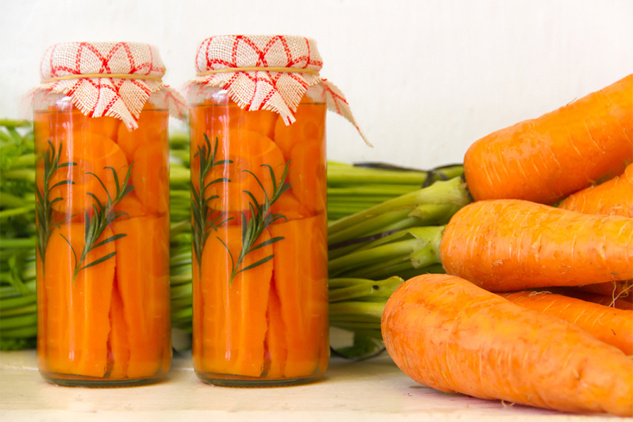 2 jars of pickled carrots and raw carrots next to them