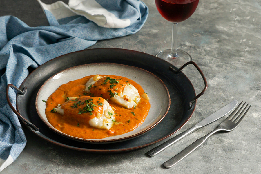 Plate with 2 cod filets in a red pepper sauce