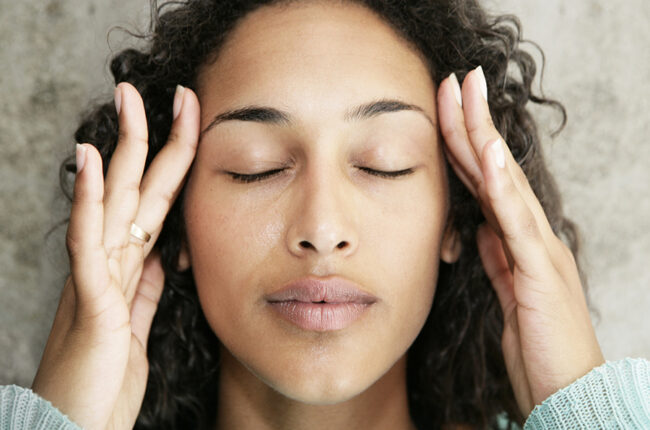 Woman rubbing sides of forehead to relax