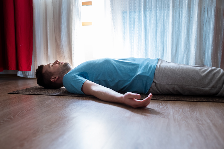 Man laying on yoga mat, yoga nidra