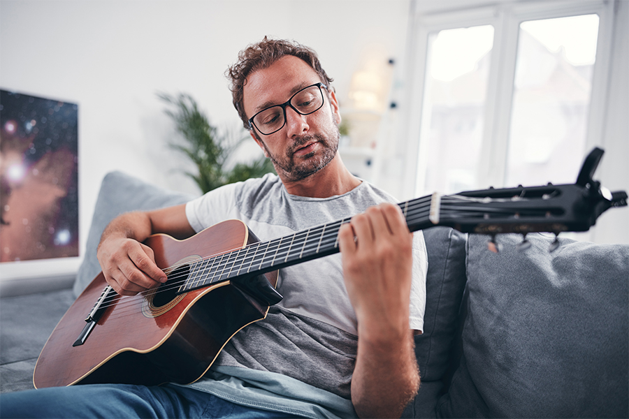 Man sitting on couch playing guitar