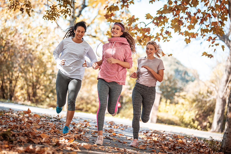 Group of women running in a park during fall