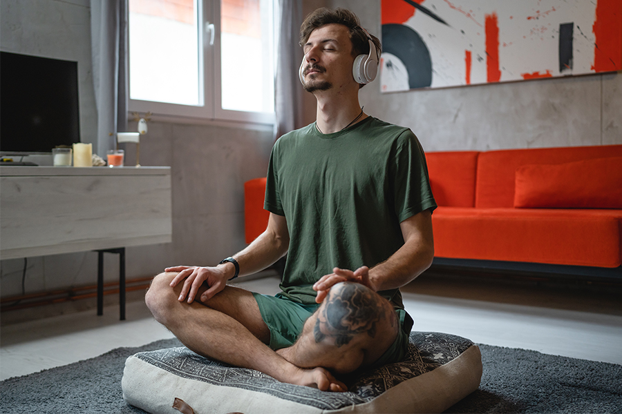 One man doing guided meditation yoga self care practice at home