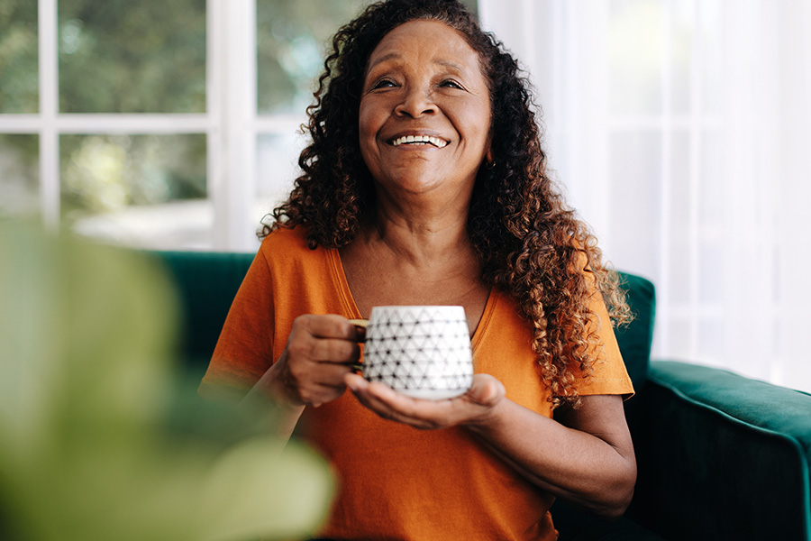 Retired woman relaxing with a warm cup of tea at home