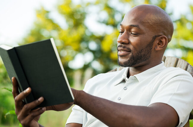 Black Man Reading Book at Park