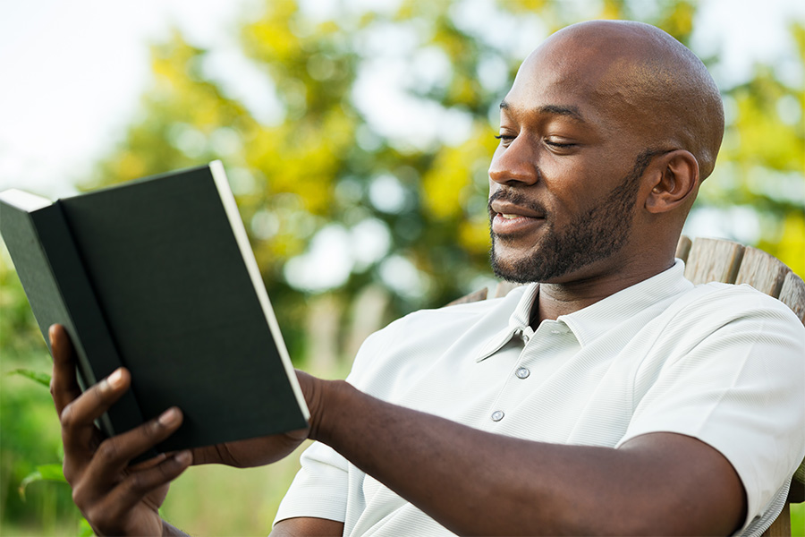 Black Man Reading Book at Park