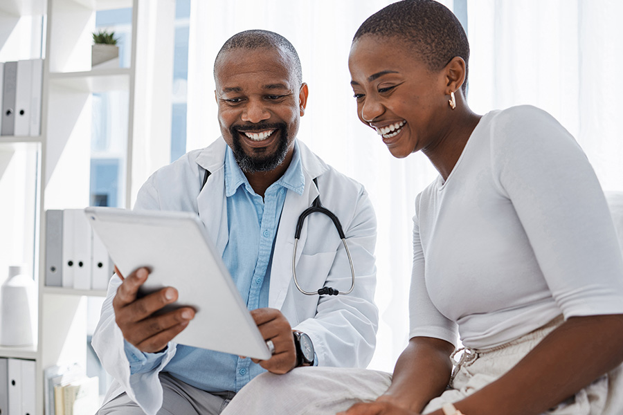 Doctor, healthcare and medicine with a patient talking test results and progress on a tablet in a hospital clinic. Trust, help and medical consulting with a professional medicare worker in his office